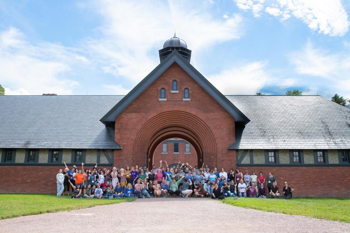 A large group of people gathered in front of the Shelburne Farms Coach Barn