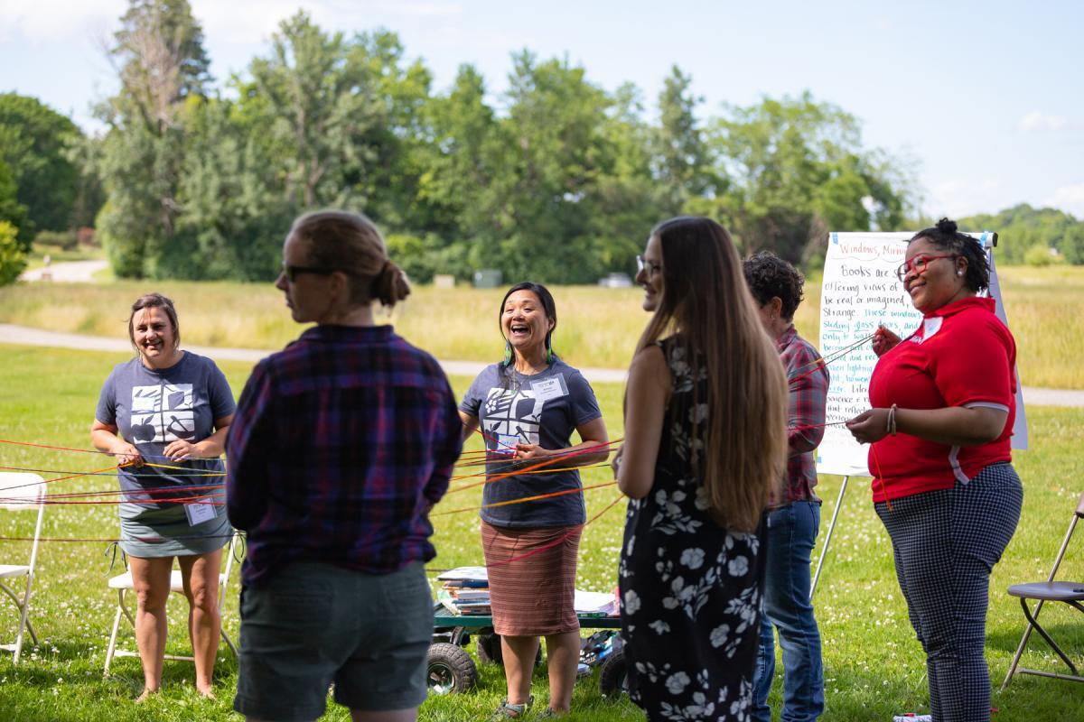Education staff and participants create a food systems web during the 2022 Northeast Farm to School Institute Summer Retreat on the Coach Barn Lawn. Education staff and participants create a food systems web during the 2022 Northeast Farm to School Institute Summer Retreat on the Coach Barn Lawn.