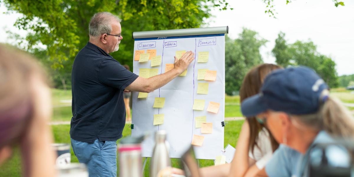 Educators work outdoors at a picnic table Educators work outdoors at a picnic table