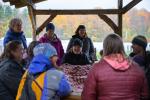 A group sits at a picnic table engaged in an activity