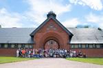 A large group of people gathered in front of the Shelburne Farms Coach Barn